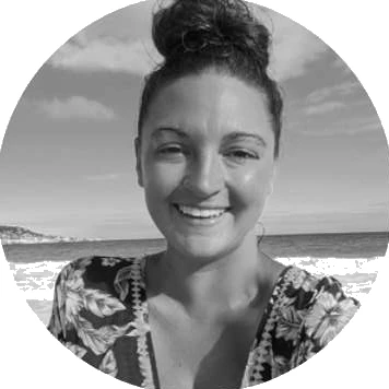 Amber Goldberg smiling on a beach, in black and white