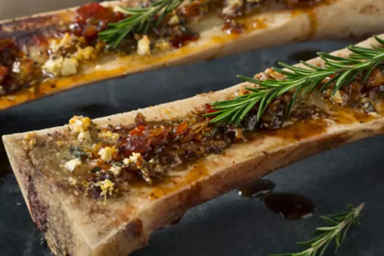 Roasted bone marrow topped with herbs and rosemary