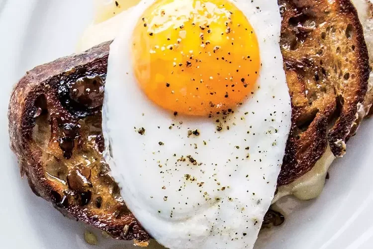 A fried egg on golden, buttery grilled bread