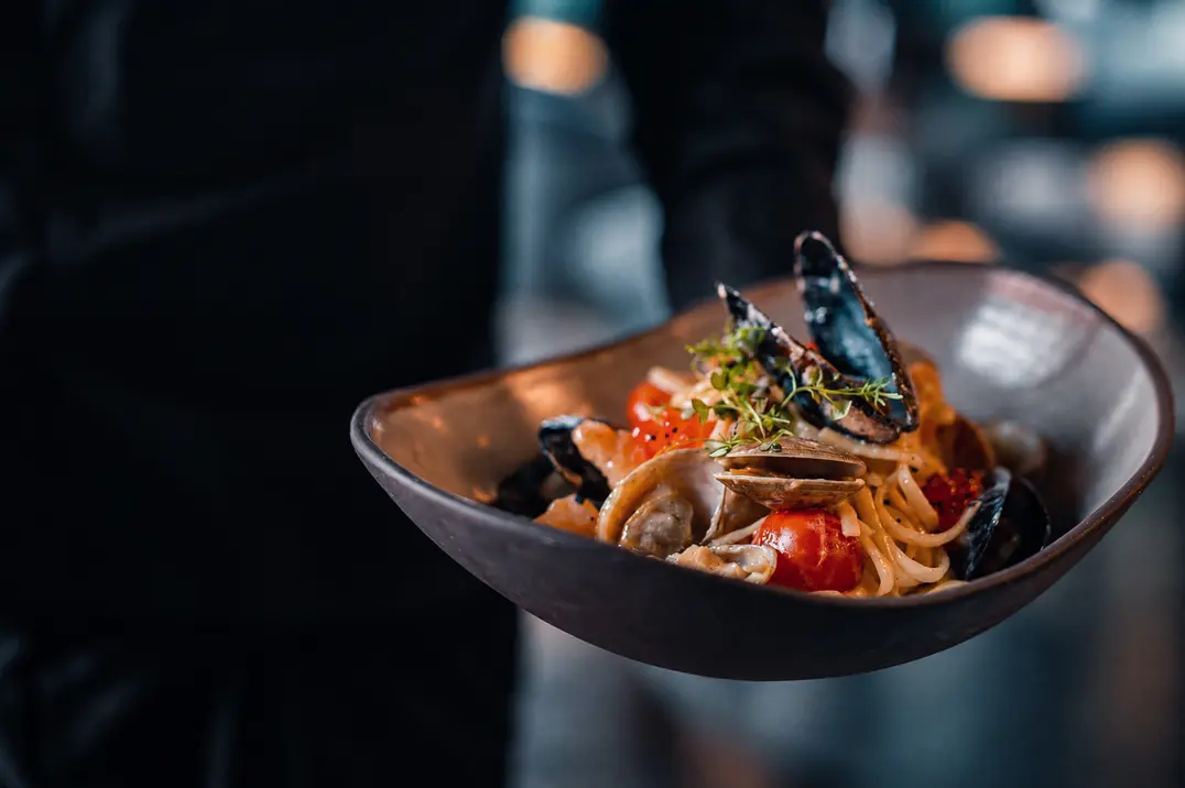 A bowl of seafood pasta at a restaurant table